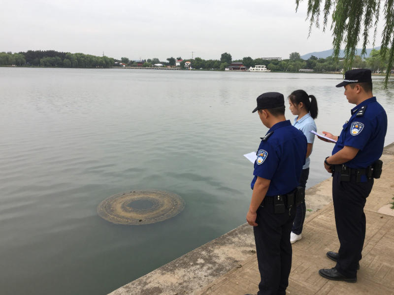 應(yīng)急監(jiān)督執(zhí)法人員在觀測(cè)河道污水排放